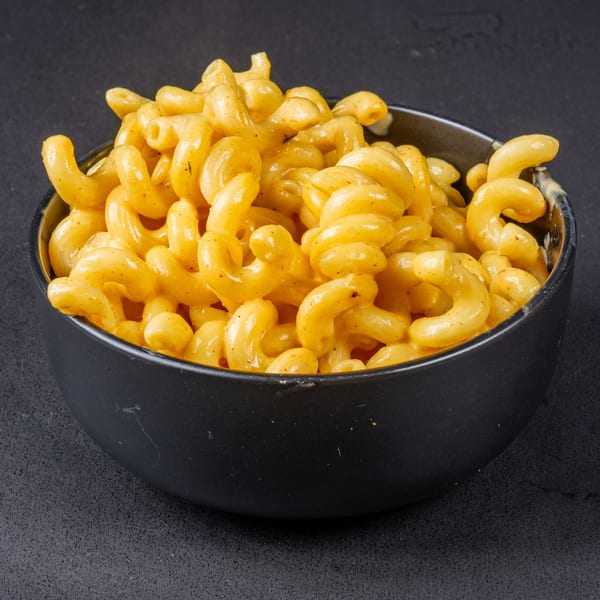 A black bowl filled with creamy, golden macaroni and cheese, ready to be served at Gardner's Grill.
